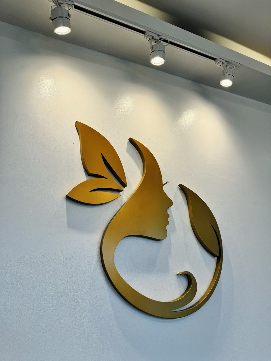 Gold Porcélaine logo mounted on a white wall under spotlights
